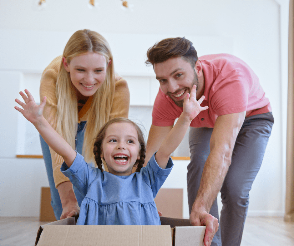 kid in a box being pushed by her parents